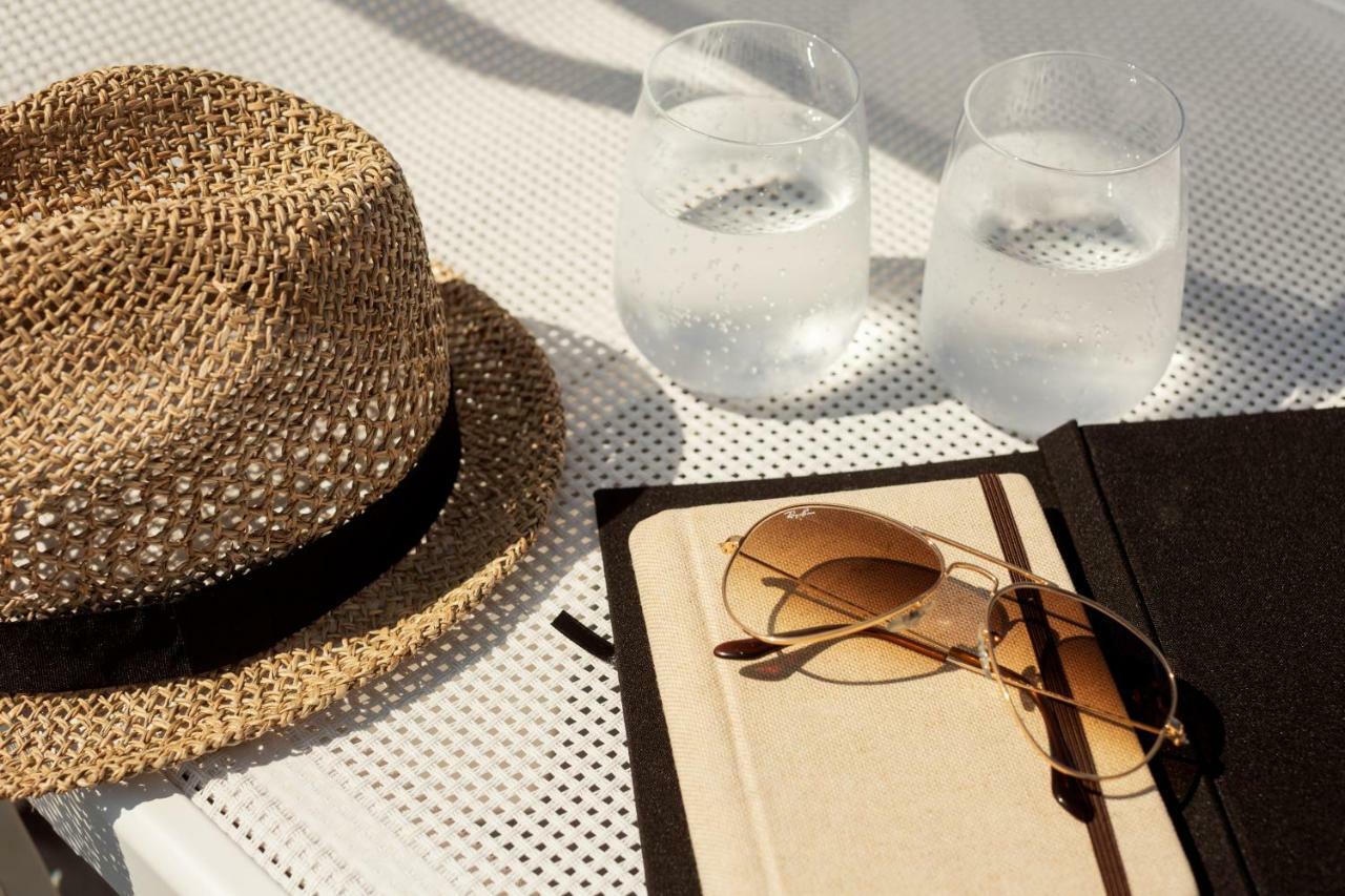 Toscana Charme Resort Tirrenia Exteriör bild A hat, sunglasses, and a book